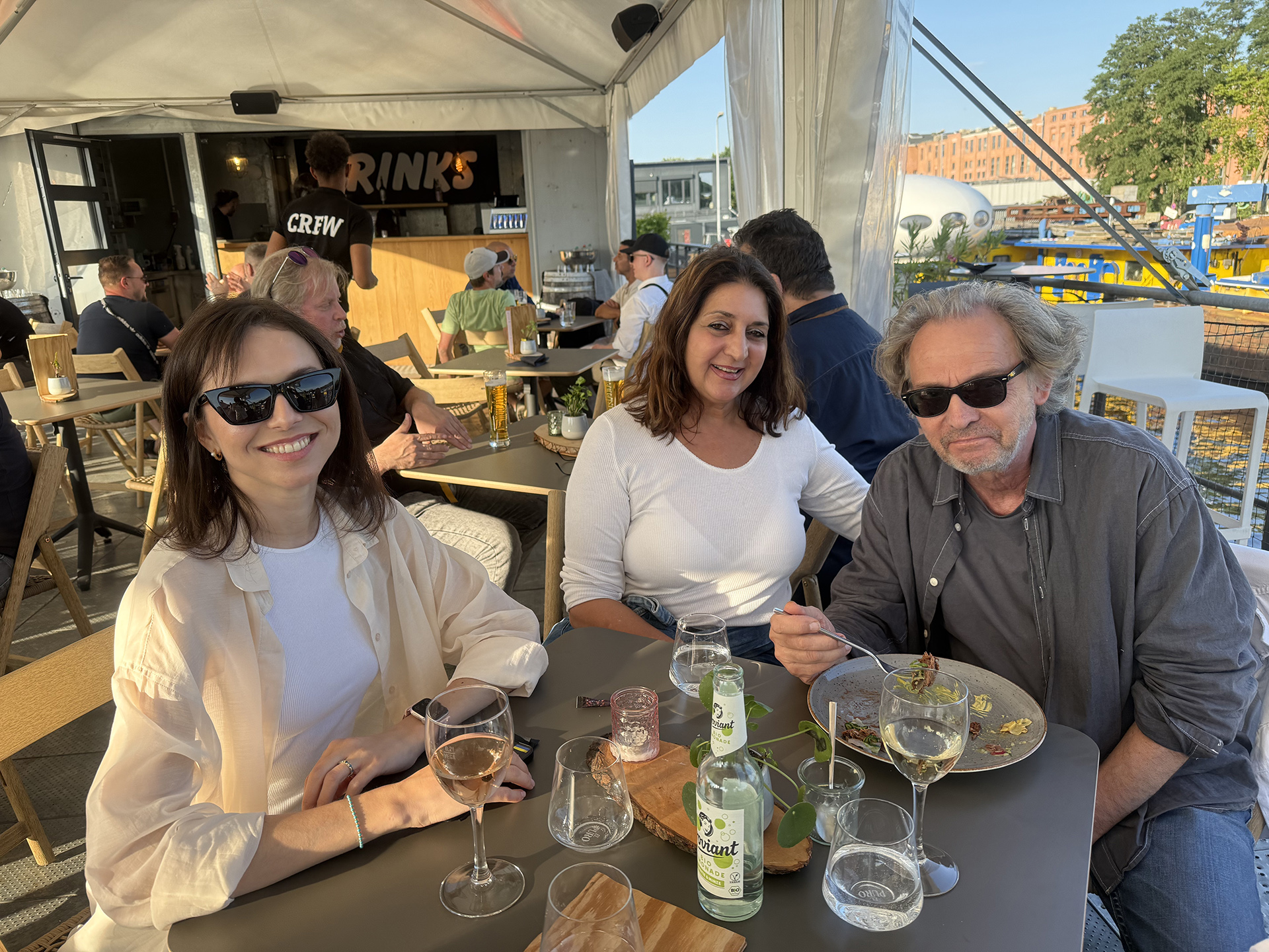JAEMACOM Kollegen beim Sommerevent 2025, gemeinsames Essen auf einer Außenterrasse mit Blick auf den Hafen